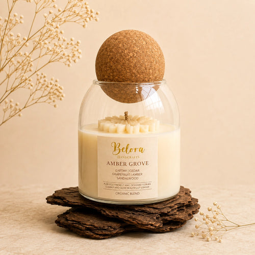 Amber Grove candle by Belora Handcrafts in a glass jar with a cork ball lid, set on a piece of bark