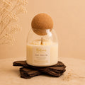Day Dream candle by Belora Handcrafts in a glass jar with a cork ball lid, set on a piece of bark