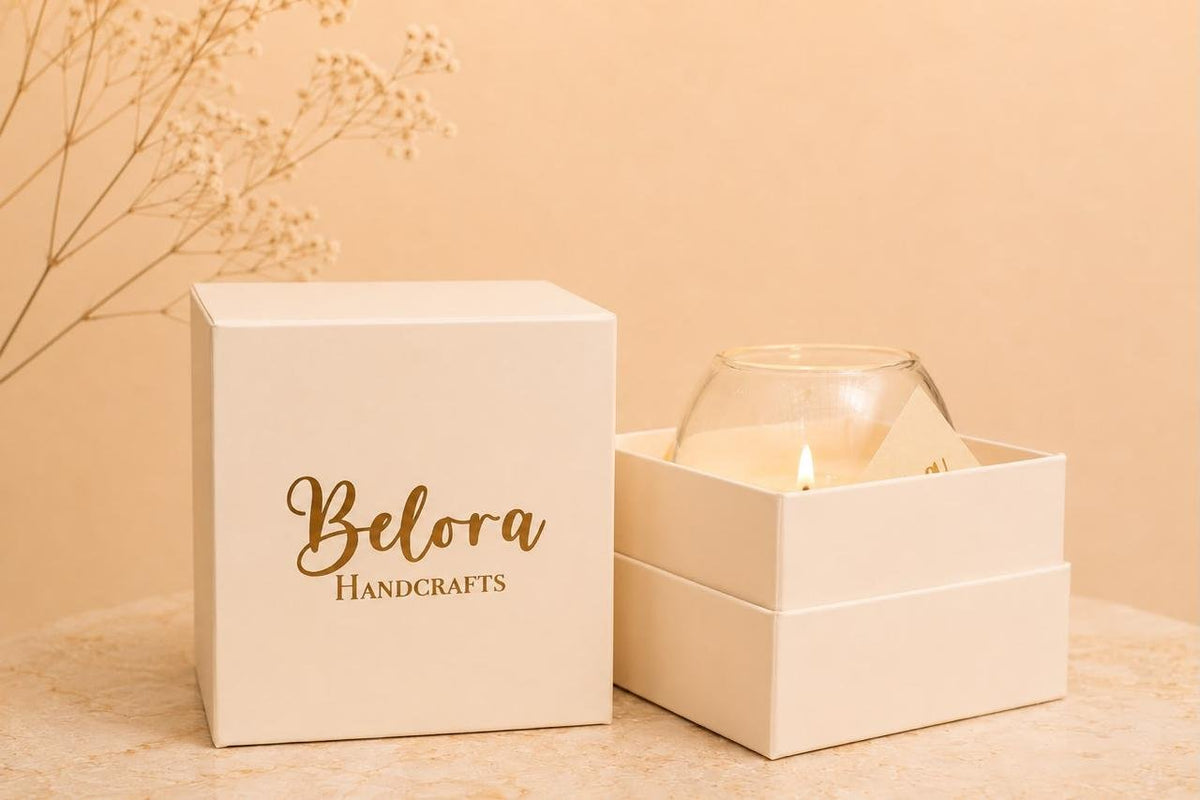 Belora Handcrafts gift box beside an open box holding a lit candle in a glass jar
